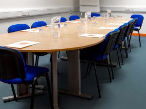 Meeting Room 1 with a table surrounded by eleven chairs and a flipchart in the corner.