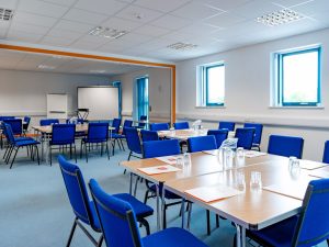 Office Q with four tables each surrounded by eight chairs.